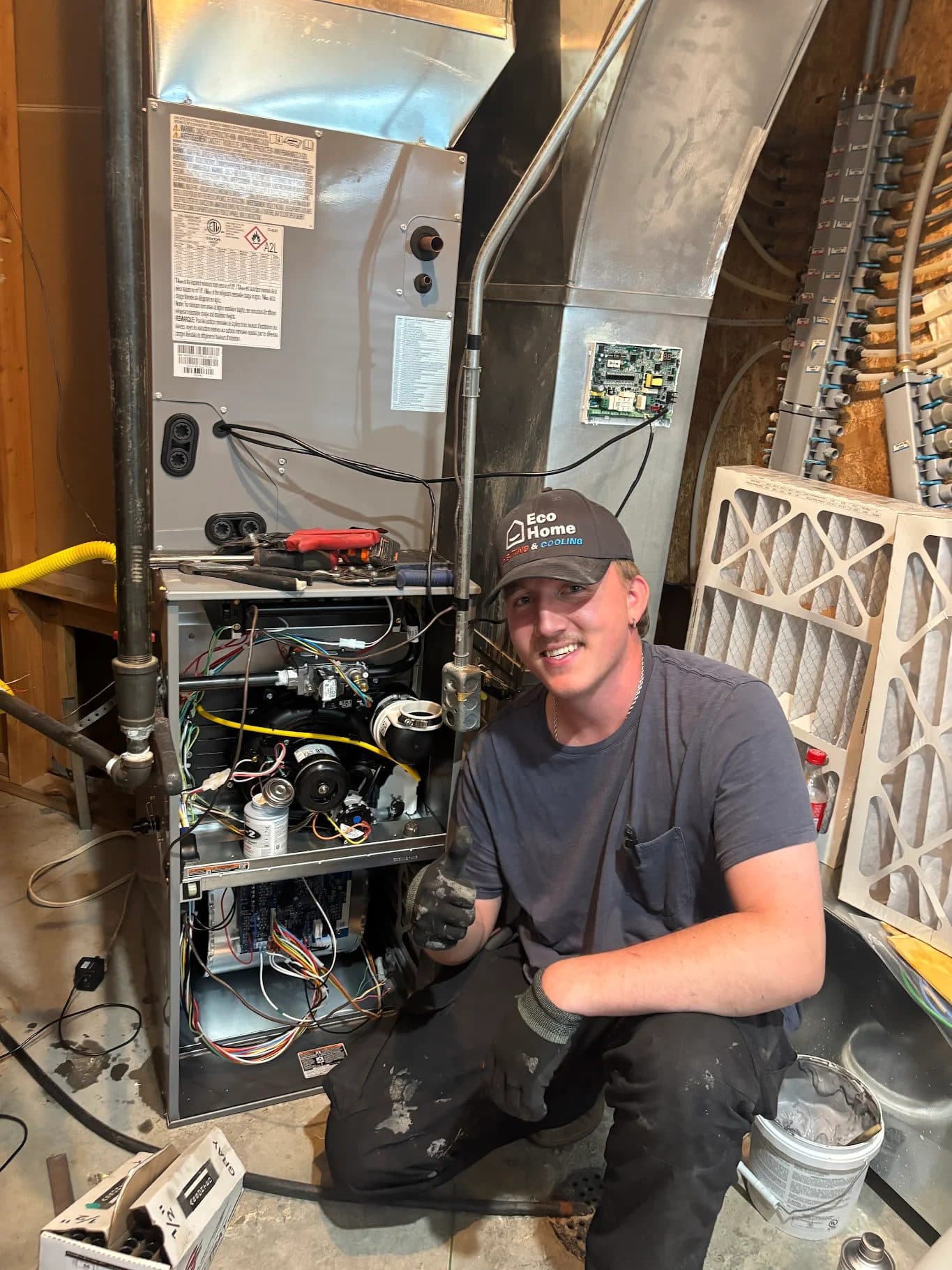 Eco Home technician giving a thumbs up beside a new gas furnace