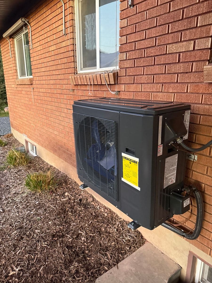 New heat pump installed by Eco Home beside a brick Utah home