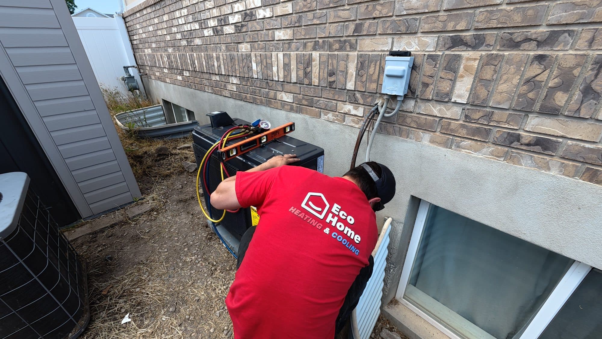 Eco Home technician leveling a new heat pump at a Utah home