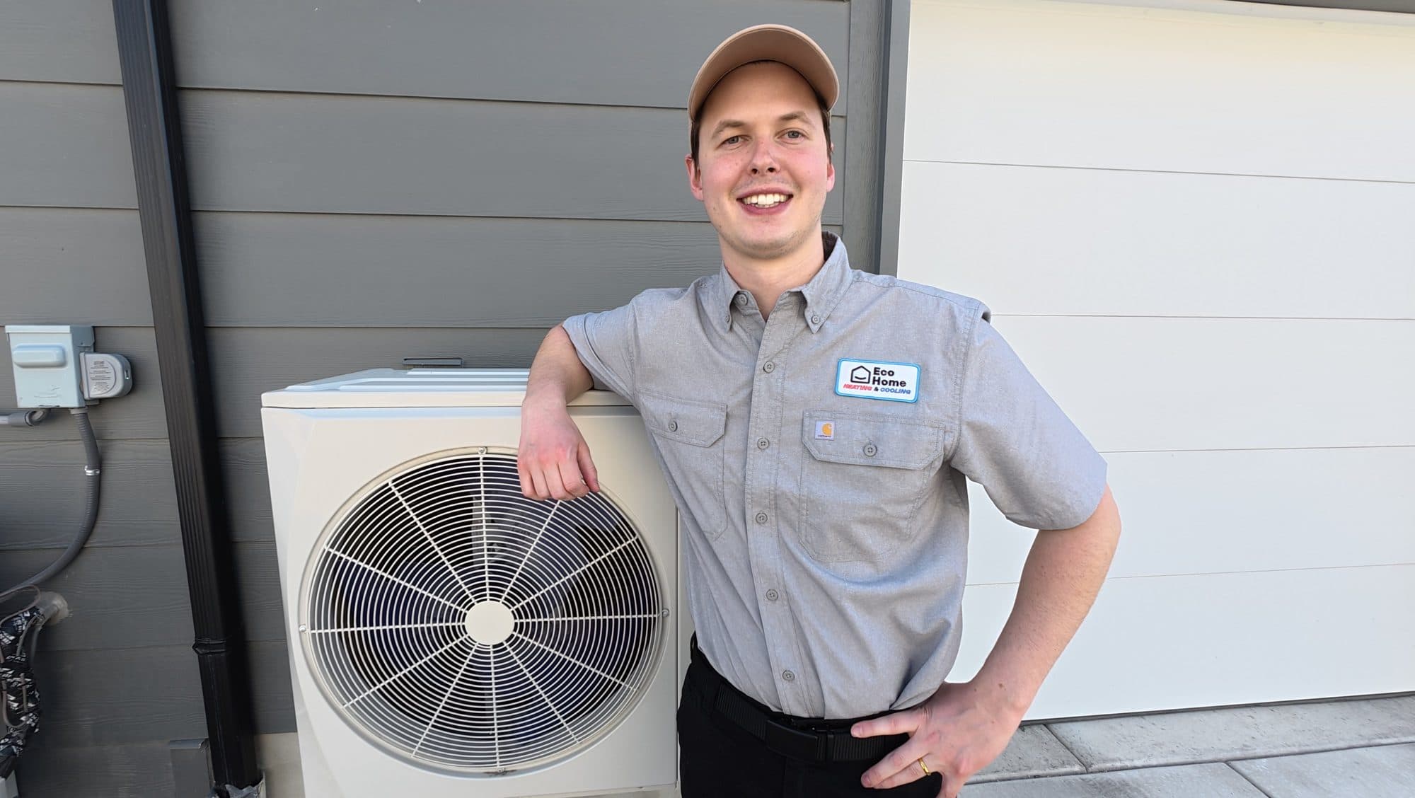 Eco Home technician next to a newly installed heat pump